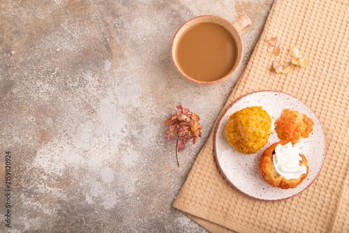 Сhoux pastry cake with cup of coffee on brown concrete, copy space, top view.