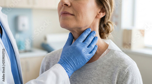 Doctor examines patient's neck for thyroid issues in medical office, healthcare concept.
