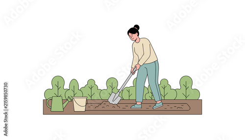 Young female gardener digging soil with a shovel in the garden bed near bushes, watering can, and bucket.
