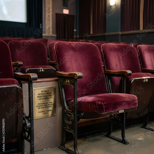 Empty vintage theater seats in a dark auditorium.