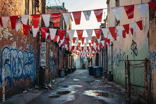 Red and white bunting flags hanging in an urban alleyway for Indonesia Independence Day