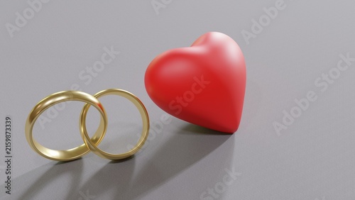 Fotografía Two interlocked gold wedding rings and a red heart on a gray background, love an