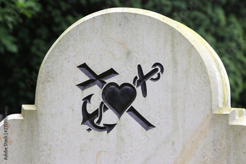 anker, herz und kreuz symbole auf einem grabstein