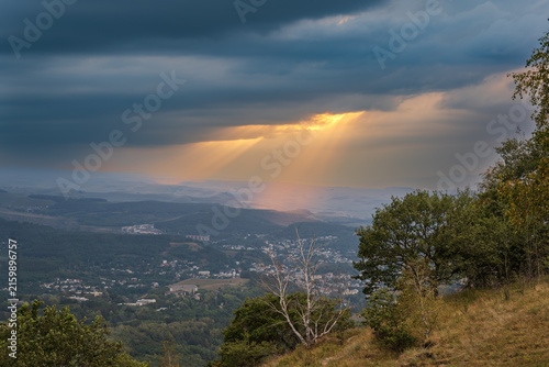 фотографія A mountain range covered in the wild woods illuminated by the golden light of the setting sun