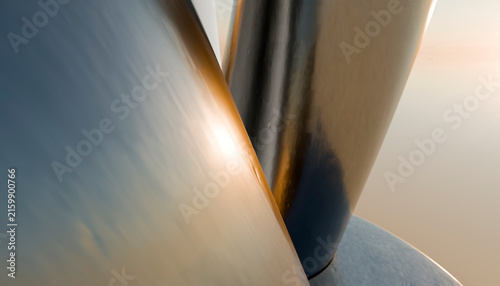 Close-up of smooth reflective curved metal surfaces with warm light