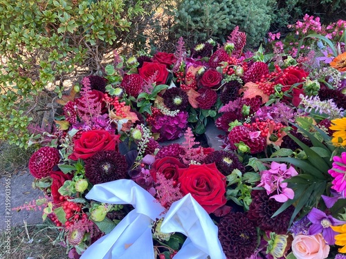 Bunte Blumen in roten Tönen im Trauer Cranz nach Beerdigung auf dem Friedhof