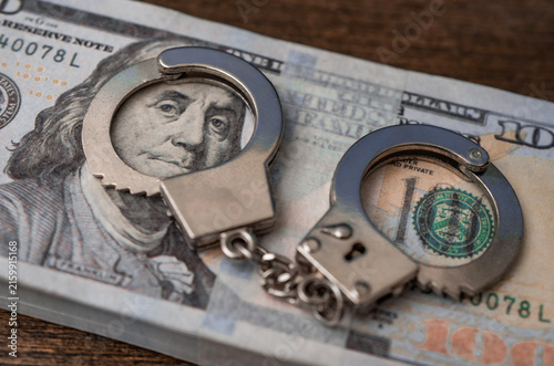 Financial Crime and Money Laundering Concept with Handcuffs on Cash