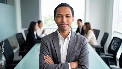 Indonesian business man investor, doubtful young male ceo executive wearing suit standing in office holding hand in chin looking away at work thinking on leadership question, feeling doubt.