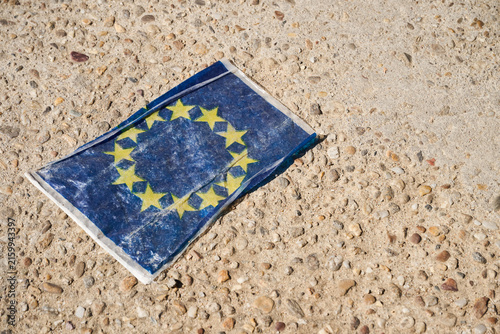 European Union flag lying crumpled on rough ground