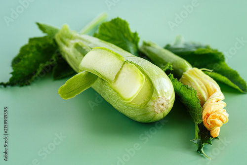 фотографія Fresh organic zucchini prepared for cooking on minimal green background