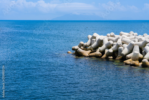 Картината върху платно Concrete Tetrapod Wave Barrier on Deep Blue Coastal Water Under Sky