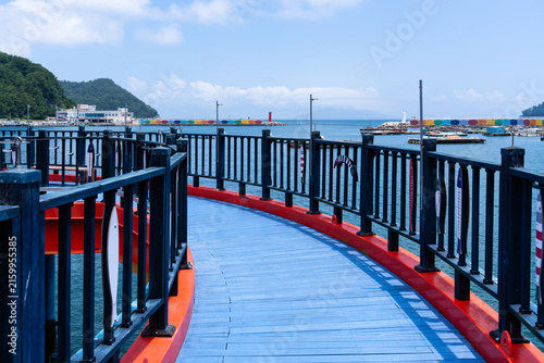 S-Curve Perspective Along Sky Blue Coastal Boardwalk Footbridge