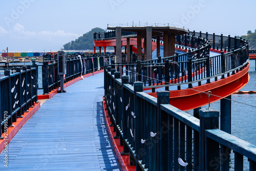 Elevated View of Winding Blue Coastal Pier Bridge with Red Edge Trim