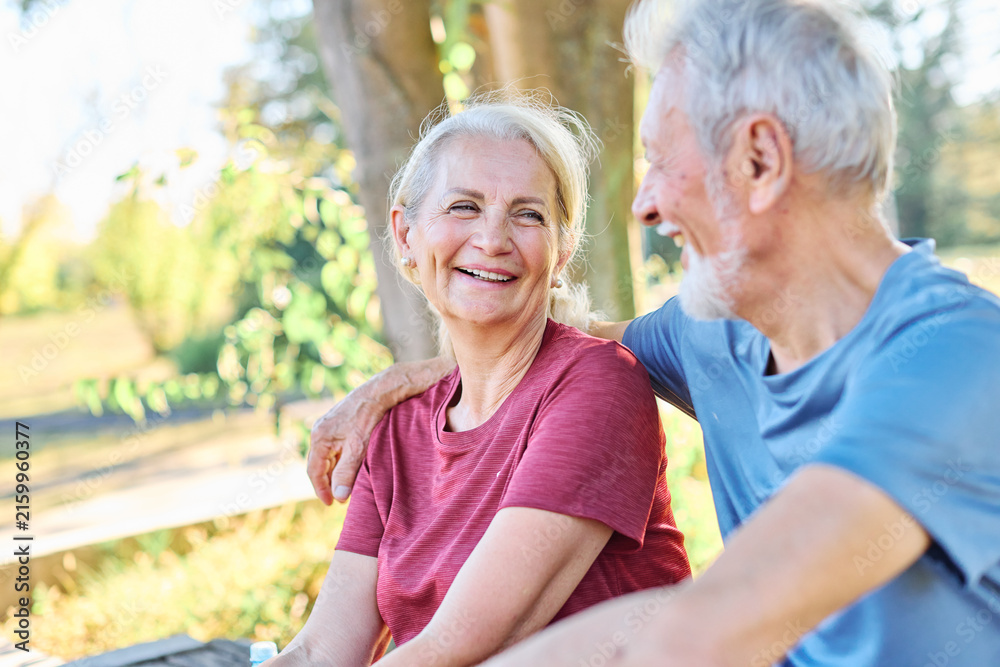 Fototapeta premium Happy active senior couple having fun talking holding hands and bonding after having an exercise in park outdoors