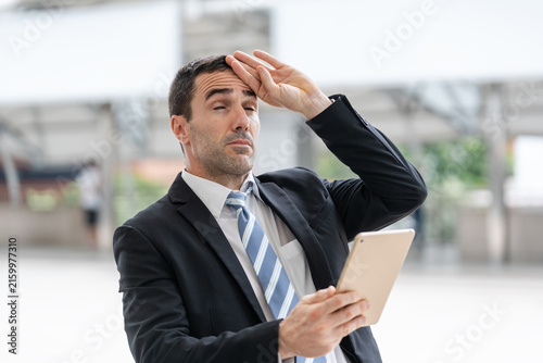 Foto An overworked and dizzy businessman one hand holding tablet and other hand touch