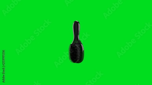 A black hair detangling brush isolated against a vibrant green screen background