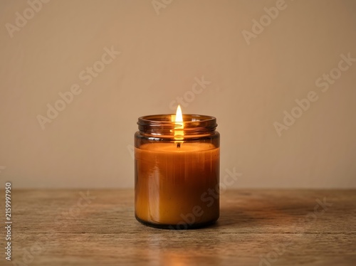Warm Amber Scented Candle Burning on a Rustic Wooden Surface for Relaxation