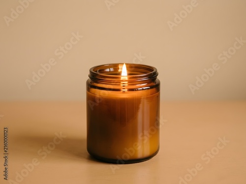 Close-up of a lit natural wax candle in a reusable glass jar, emitting a gentle glow