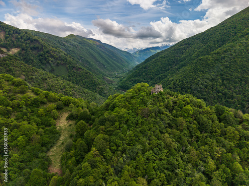 Aerial view of the ruins of Chateau de la Garde situated on a forested hill overlooking the confluence of the Le Salat and LAlet rivers in the Pyrenees mountains, Seix, Occitanie, France.