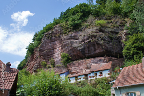 Historische, blaue Felsenhäuser von Graufthal, eingebaut in die rosa Sandsteinwand
