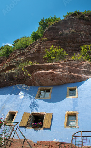 Historische Felsenhäuser von Graufthal. Blaue Fassaden der Halbhöhlenwohnungen, eingebaut in die rosa Sandsteinwand, Detail