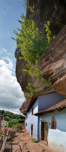 Historische Felsenhäuser von Graufthal. Blaue Fassaden der Halbhöhlenwohnungen, eingebaut in die rosa Sandsteinwand