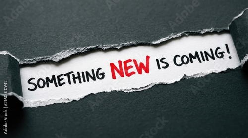 Foto Something New is Coming message revealed through torn black paper, teaser announ