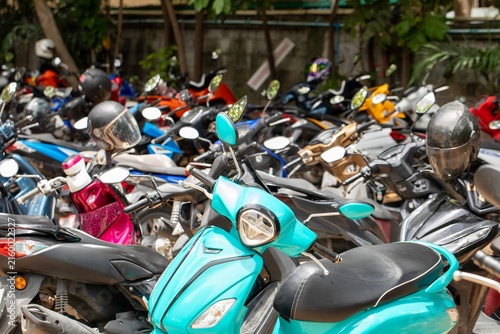 Bild auf Leinwand Densely packed motorcycles and scooters parked closely together in outdoor parki