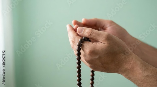 Tapety artystyczne Hands holding prayer beads.