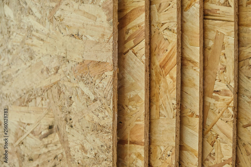 Close up perspective multiple stacked OSB wood boards showing textured edges and surface grain.