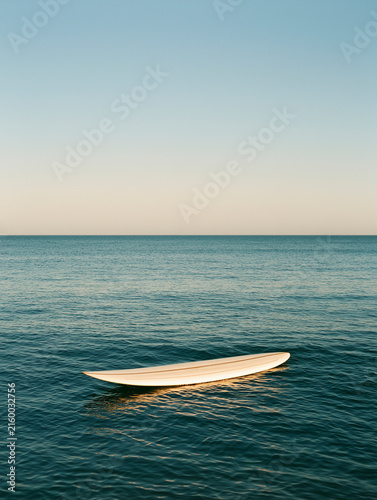 White Surfboard Floating In Calm Ocean