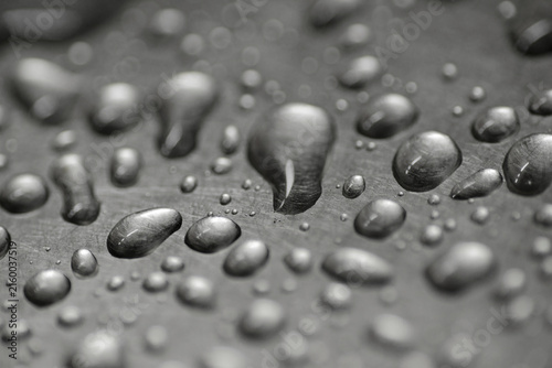 Water droplets on dark surface with dramatic monochrome texture.