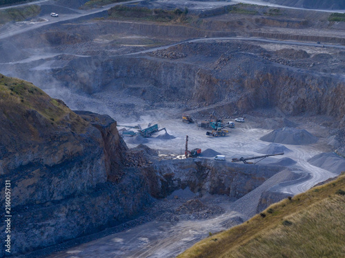Aerial view of an active quarry with heavy machinery, piles of crushed stone, and excavation equipment in Drogheda, County Louth, Ireland.
