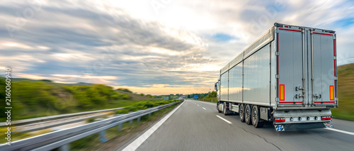 Truck trailer on highway. Freight transport and delivery route.