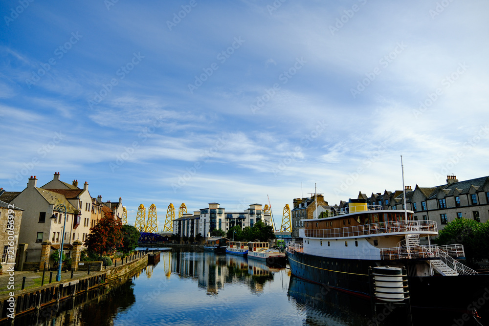 Fototapeta premium River passes through Leith, Scotland and reveals wind turbines under construction