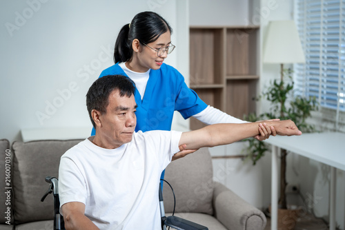 Foto Young caregiver helping an older man stretch his arm during home rehabilitation in a bright living room, supporting recovery and mobility