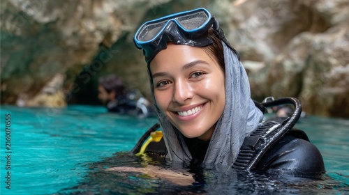 Female scuba diver smiling while floating in cave water pool