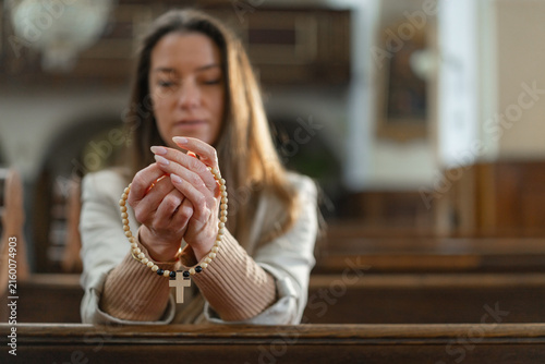 Obraz na plátně A woman prays in a European Catholic church during Holy Mass, showing her faith and devotion