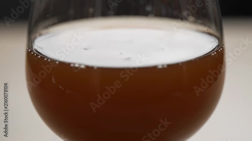 Extreme Close-up of Frothy Foam Head on Dark Beer or Carbonated Beverage Poured into a Glass, Showing Bubbles, Texture, and Refreshing Liquid.