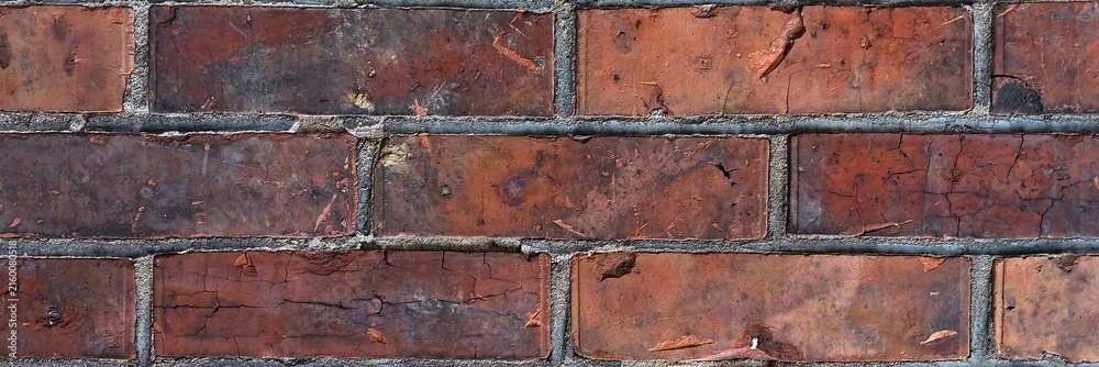 Fototapeta premium Weathered red brick wall surface showing rustic texture and aged masonry