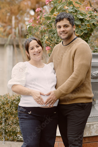 Canvastavla Young couple celebrating late term pregnancy in an autumn setting, showing love, tenderness and anticipation as they form a heart over the nine month belly surrounded by warm seasonal colors