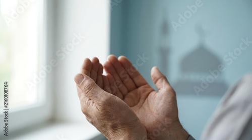 Person making dua with mosque shadow on the wall.