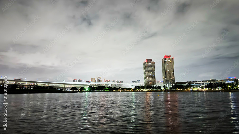 Fototapeta premium Modern Waterfront Skyline with Illuminated High-Rise Buildings at Night
