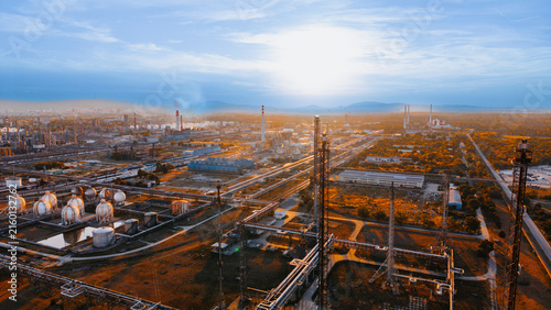 Foto Oil refinery and pipe racks beside wooded industrial grounds