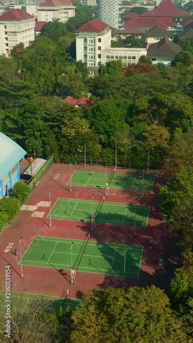 Aerial view of urban tennis courts surrounded by trees