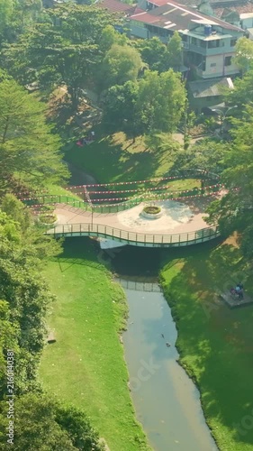 Aerial view of curved park bridge crossing canal in Yogyakarta