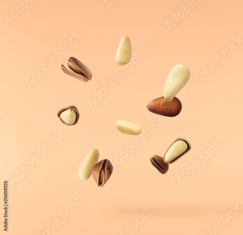 Canvastavla Fresh raw pine nuts flying in the air isolated