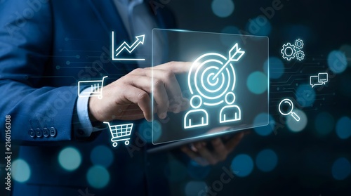 A professional businessman interacting with a digital tablet displaying a glowing holographic image of business targets and analytical growth marketing strategy icons