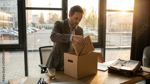Reflective Businessman Packing Up Office Desk on Last Day of Work