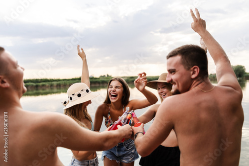 Cuadro en lienzo Friends Enjoy Summer Fun by the River While Laughing and Sharing Drinks